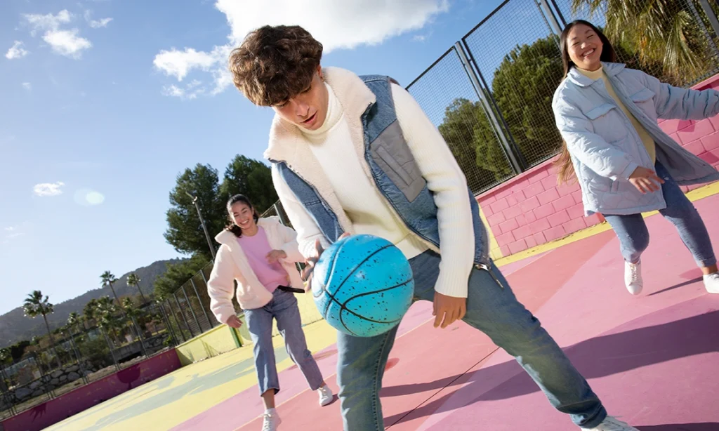 High school athletes practicing basketball symbolize the importance of balancing sports with academics performance for success.