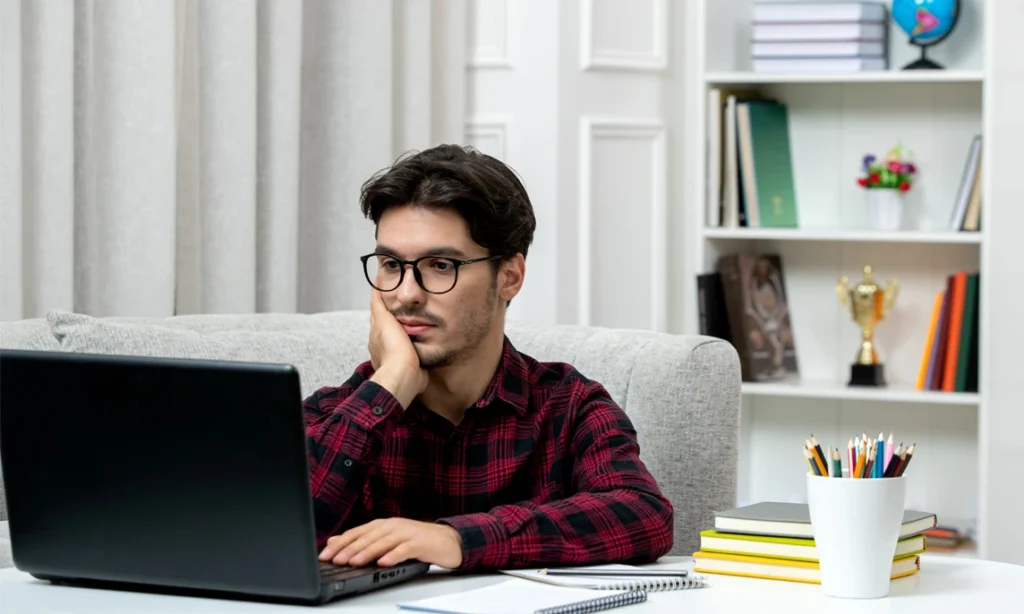 Student planning for college admissions while researching universities on a laptop at home.